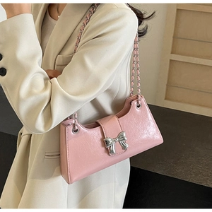 Dettaglio borsa baguette rosa in PU con fiocco argento e tracolla a catena intrecciata