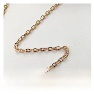 Macro shot of high-polished gold chain strap with O-link structure on white velvet fabric