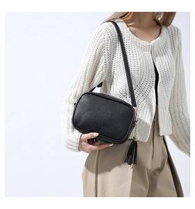 Close-up of black litchi grain PU leather crossbody bag with elegant fringe tassel detail