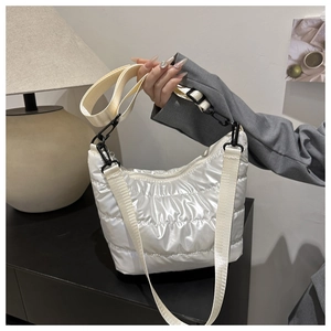 Detail of white quilted nylon shoulder bag with adjustable strap and metallic hardware