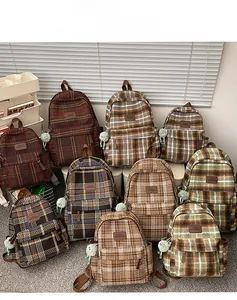 Vue détaillée des sacs à dos en toile à carreaux avec écussons en cuir et breloques peluche