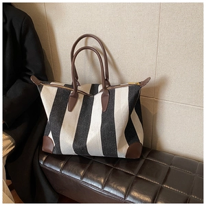 Grande borsa tote in tela a righe bianche e nere con rifiniture in pelle marrone moda