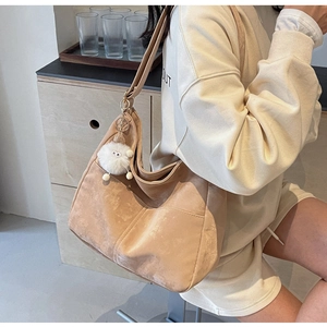 Detail of khaki suede Hobo shoulder bag featuring a cute white plush lamb charm