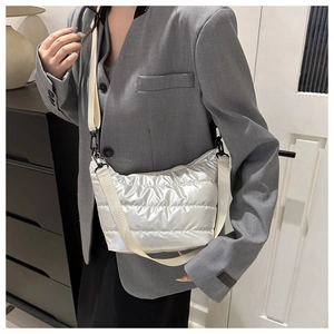 Detail view of white quilted puffer crossbody bag with adjustable canvas shoulder strap