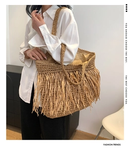 Dettaglio della borsa in paglia con nappe decorative e spalline intrecciate in stile boho