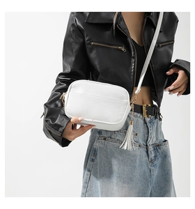 Detail of white PU leather crossbody bag with lychee texture and fringe tassel