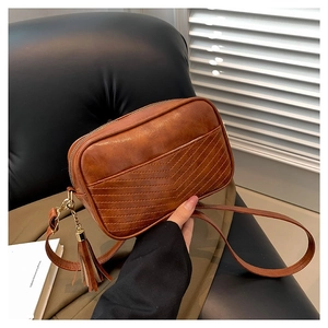 Brown PU leather crossbody bag with V-shaped quilting and removable tassel detail