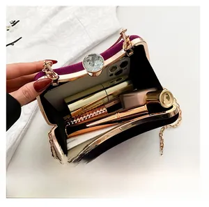 Detail view of purple velvet evening bag showing interior space with phone and lipstick
