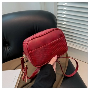 Burgundy PU leather crossbody bag featuring chevron quilting and decorative tassel