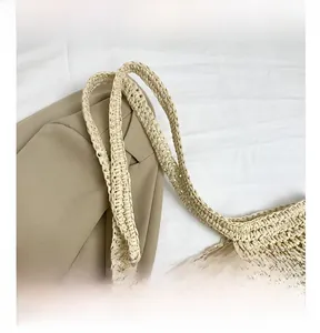 Dettaglio della borsa in paglia intrecciata con texture naturale e manico intrecciato
