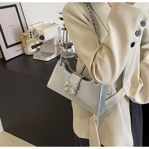 Borsa a spalla argento con fiocco metallico e catena indossata da una modella