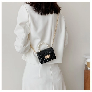 Détail d'un mini sac matelassé noir avec poignée en perles et bandoulière chaîne dorée