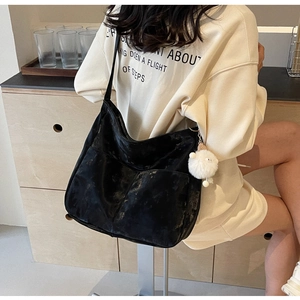 Close-up of black retro large capacity tote bag with white plush ball charm detail