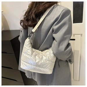 Detailed close-up of quilted puffer bag showing texture and adjustable shoulder strap