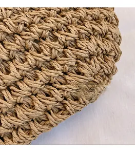 Close-up of the light brown woven texture and natural material of the crossbody bag