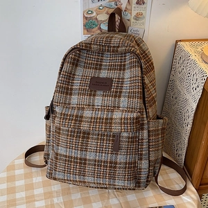 Sac à dos en tweed à carreaux marron et beige avec étiquette cuir et poches latérales
