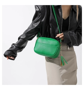 Bright green lychee grain leather crossbody bag with fringe tassel shown on model