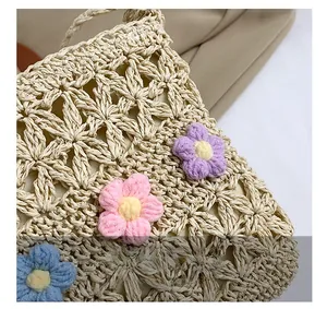 Detail of hand-woven straw bag with colorful crochet flowers and openwork pattern