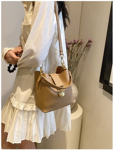 Détail de la texture en cuir grainé et des ferrures dorées sur le sac seau marron chic