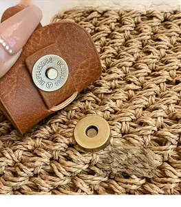 Macro shot of vintage metal magnetic buckle and woven texture on a spring handbag