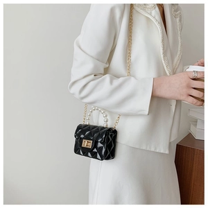 Détail du mini sac matelassé noir avec poignée en perles et chaîne dorée
