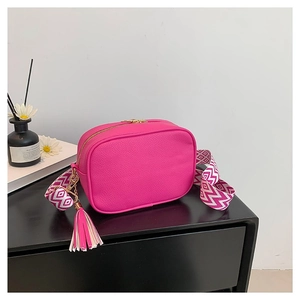 Pink minimalist crossbody camera bag in pebble leather with a jacquard woven strap