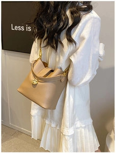 Gros plan sur le sac seau en cuir PU beige avec détails dorés et grain de cuir