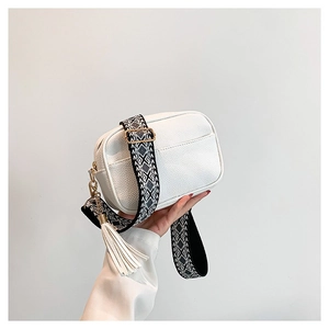 White faux leather crossbody bag with geometric shoulder strap and leather fringe tassel