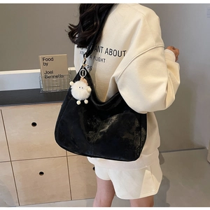 Rear view of a minimalist black oversized PU shoulder bag with a plush sheep pendant