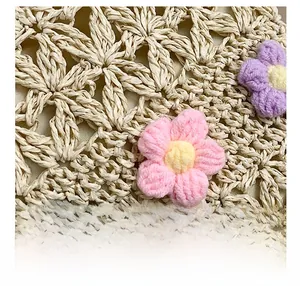 Detailed macro view of woven straw bag with colorful crochet flower decorations