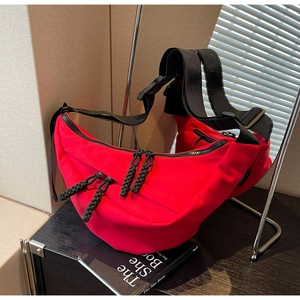 Fashionable red nylon crescent crossbody bag with black woven straps for casual styling