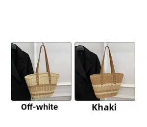 Detail of hand-woven straw tote bags in beige and khaki stripes with leather handles