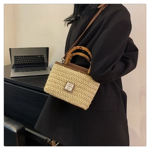 Detail of woven straw handbag with bamboo handle and leather Good Weekend patch