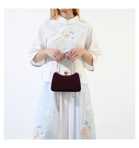 Deep burgundy velvet evening clutch bag featuring a gold metal handle and chain strap