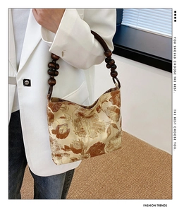 Detail der Jacquard-Seidenhandtasche mit braunen Blumenmustern und Holzperlengriff