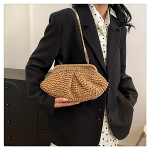 Detailed macro view of khaki woven cloud bag with elegant gold metal chain strap