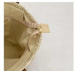 Detailed close-up of metal zipper and woven texture with inner pocket on straw bag