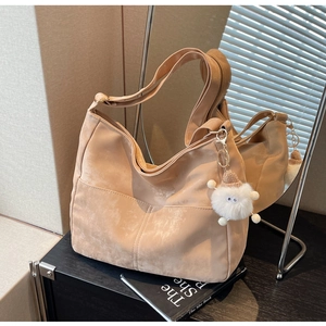 Chic 2024 apricot faux suede crossbody bag with wide strap and plush pendant