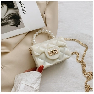 Détail du sac en gelée matelassé blanc avec poignée en perles et fermoir doré
