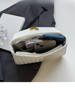 Top view of white quilted PU leather bag interior with gold heart clasp and storage space