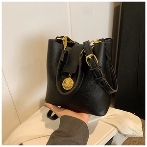 Sac seau chic en cuir grainé noir avec détails dorés et pendentif tête de lion