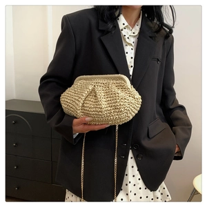 Detail of beige woven cloud bag with fine texture and elegant gold chain strap