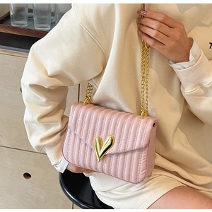Pink quilted PU leather crossbody bag with golden heart-shaped lock and chain strap detail