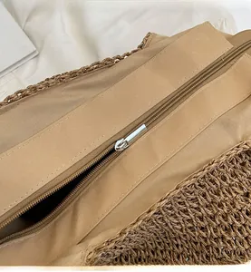Detail of a woven handbag featuring a smooth gold-toned metal zipper closure system