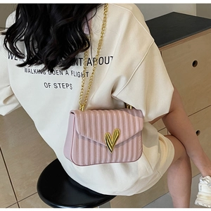 Detailed side view of pink quilted PU leather crossbody bag with golden heart clasp