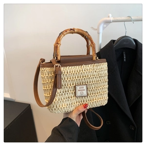 Chic woven straw handbag with bamboo top handle and brown leather strap for women