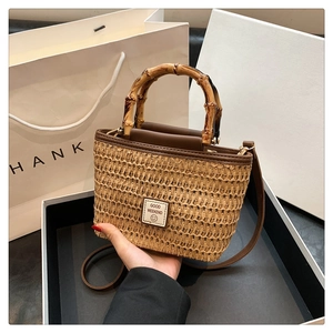 Fashionable woven straw handbag with bamboo handles and adjustable crossbody strap
