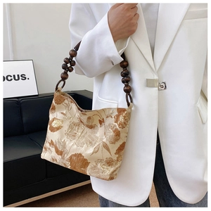 Detail einer Vintage-Handtasche aus Seide mit floralem Muster und Holzperlengriff