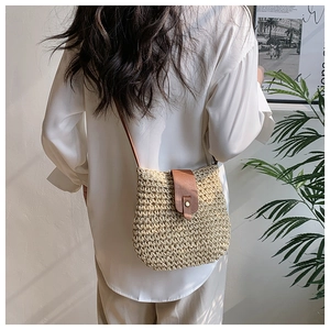 Detail of hand-woven crossbody bag with beige texture and brown leather flap