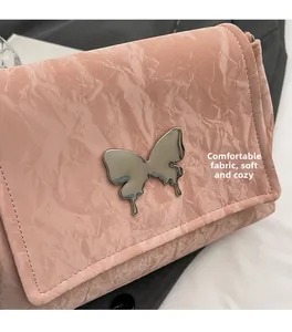 Détail d'un sac rose mode avec tissu plissé et boucle papillon en métal argenté